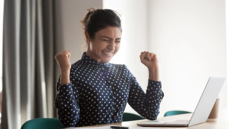 Woman excitedly looking at her computer