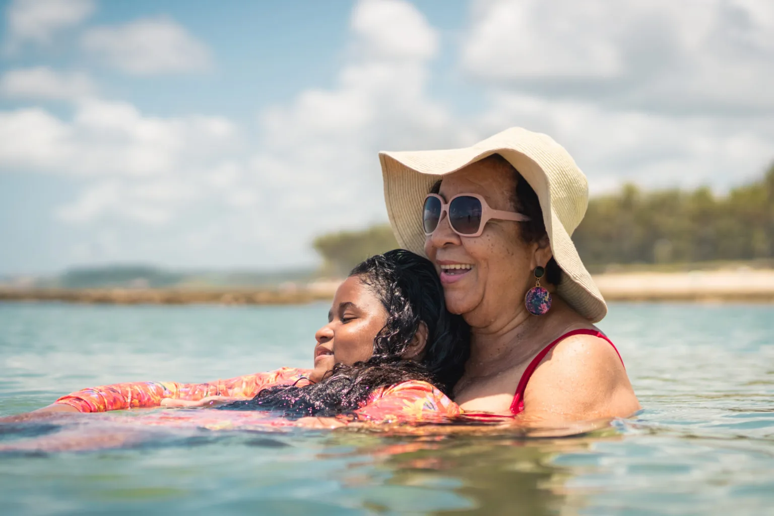 mother and daughter swimming in the ocean smiling