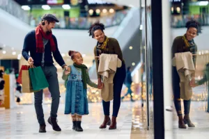 Happy multiracial family window shopping at the mall during winter holidays.