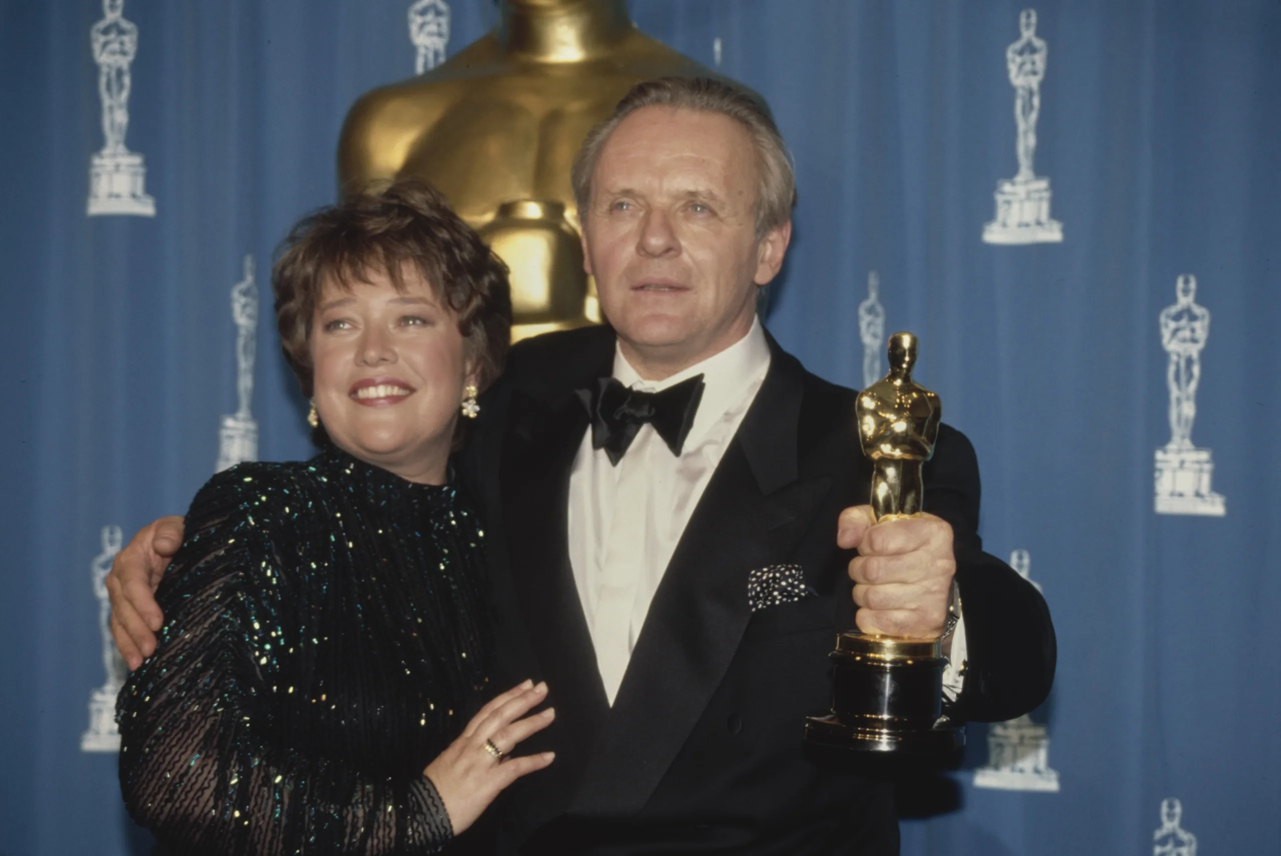 American actress Kathy Bates with British actor Anthony Hopkins, holding his Best Actor award, in the press room of the 64th Annual Academy Awards, held at the Dorothy Chandler Pavilion in Los Angeles, California, 30th March 1992. Bates had presented the award to Hopkins, which he won for his performance in 'The Silence of the Lambs'. (Photo by Vinnie Zuffante/Getty Images)