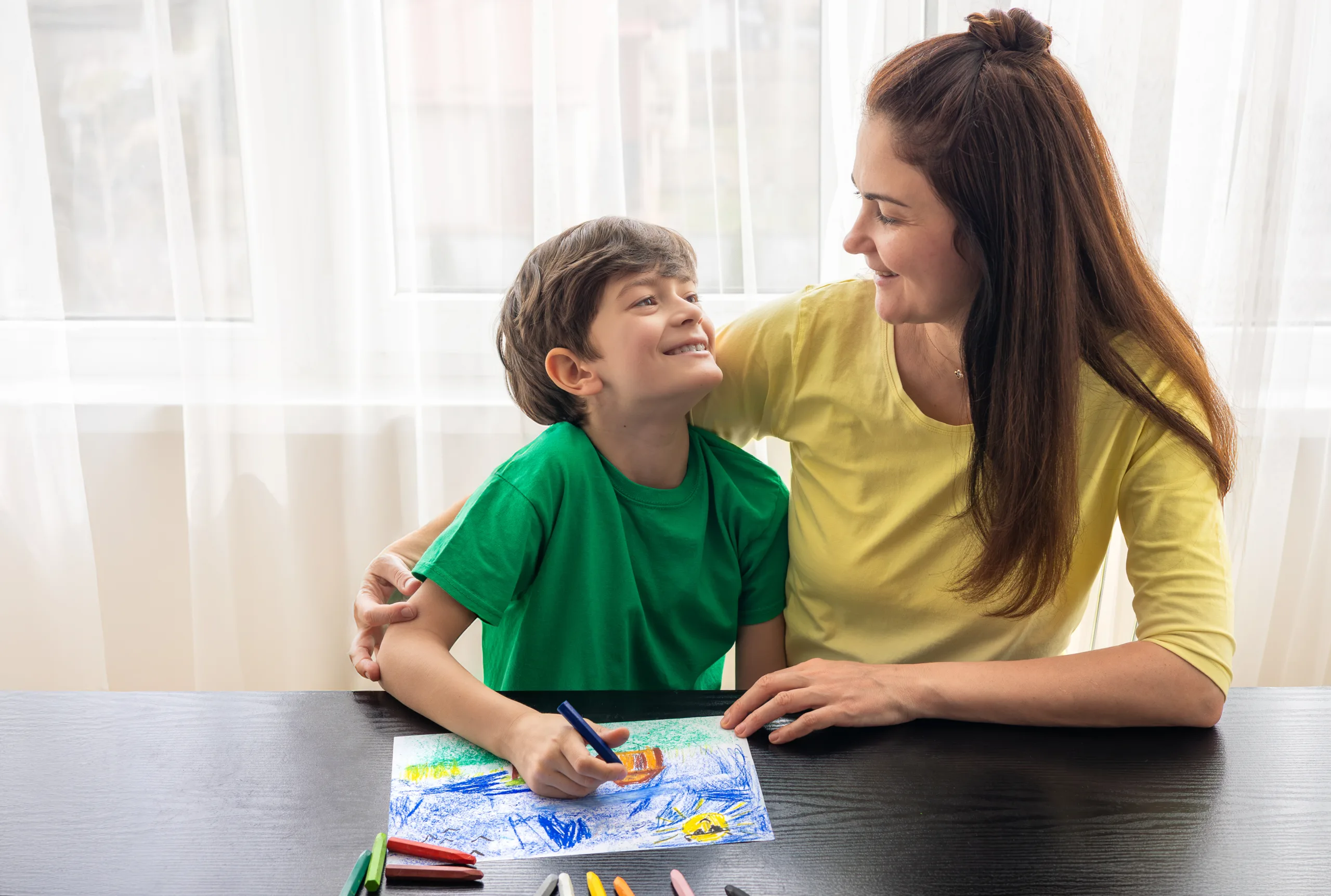 Mother and Son Drawing Together - Family Creative Time with Colorful Crayons at Home. Art therapy for children. Child psychologist, autism, ADHD. Quality time for parents and children. Copyspace