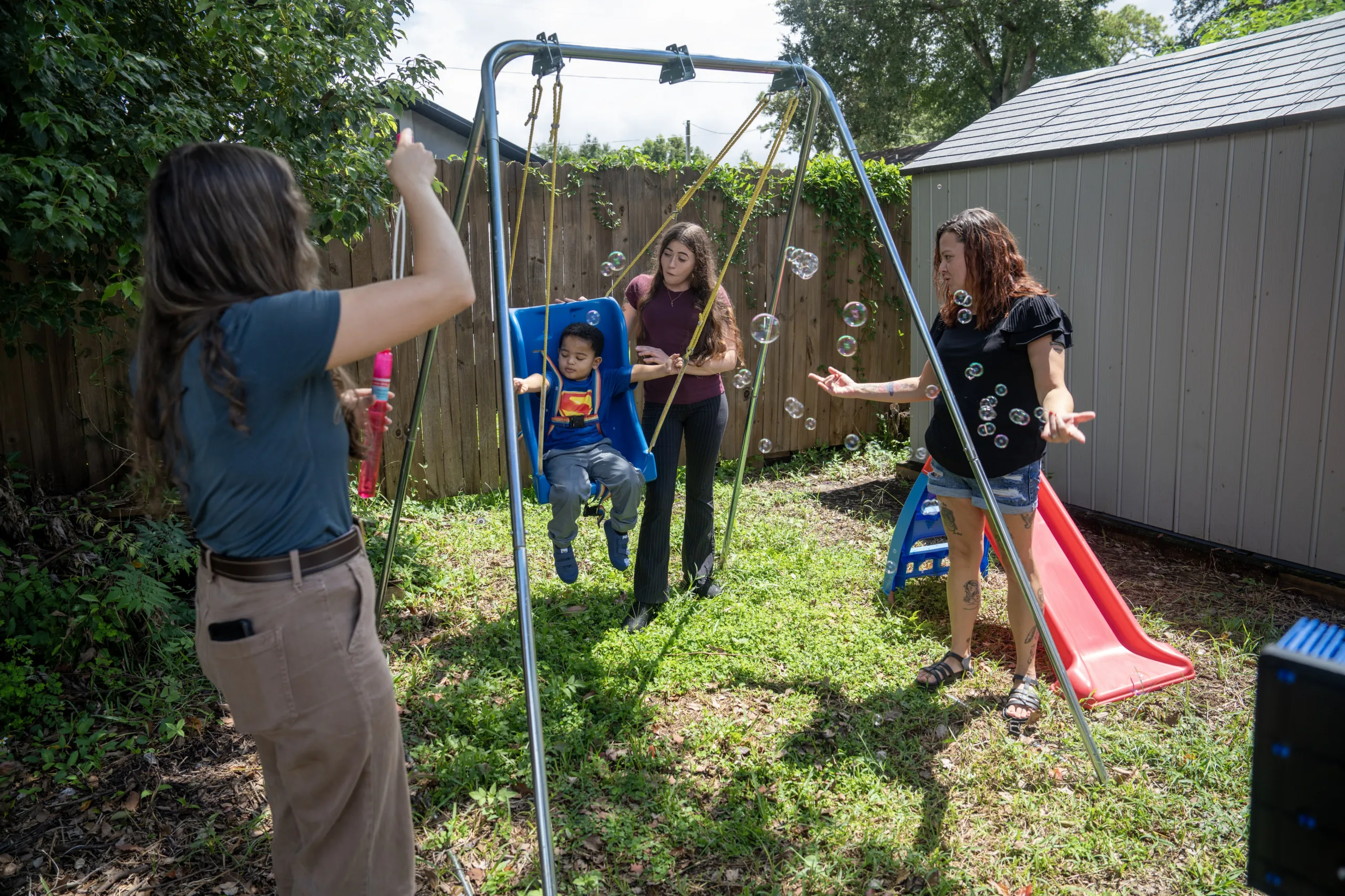 Mackenzie Leischner playing with her client, pushing them on a swing